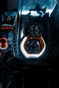 KTM adventure motorcycle with custom LED headlight by 3Dit in workshop garage setting