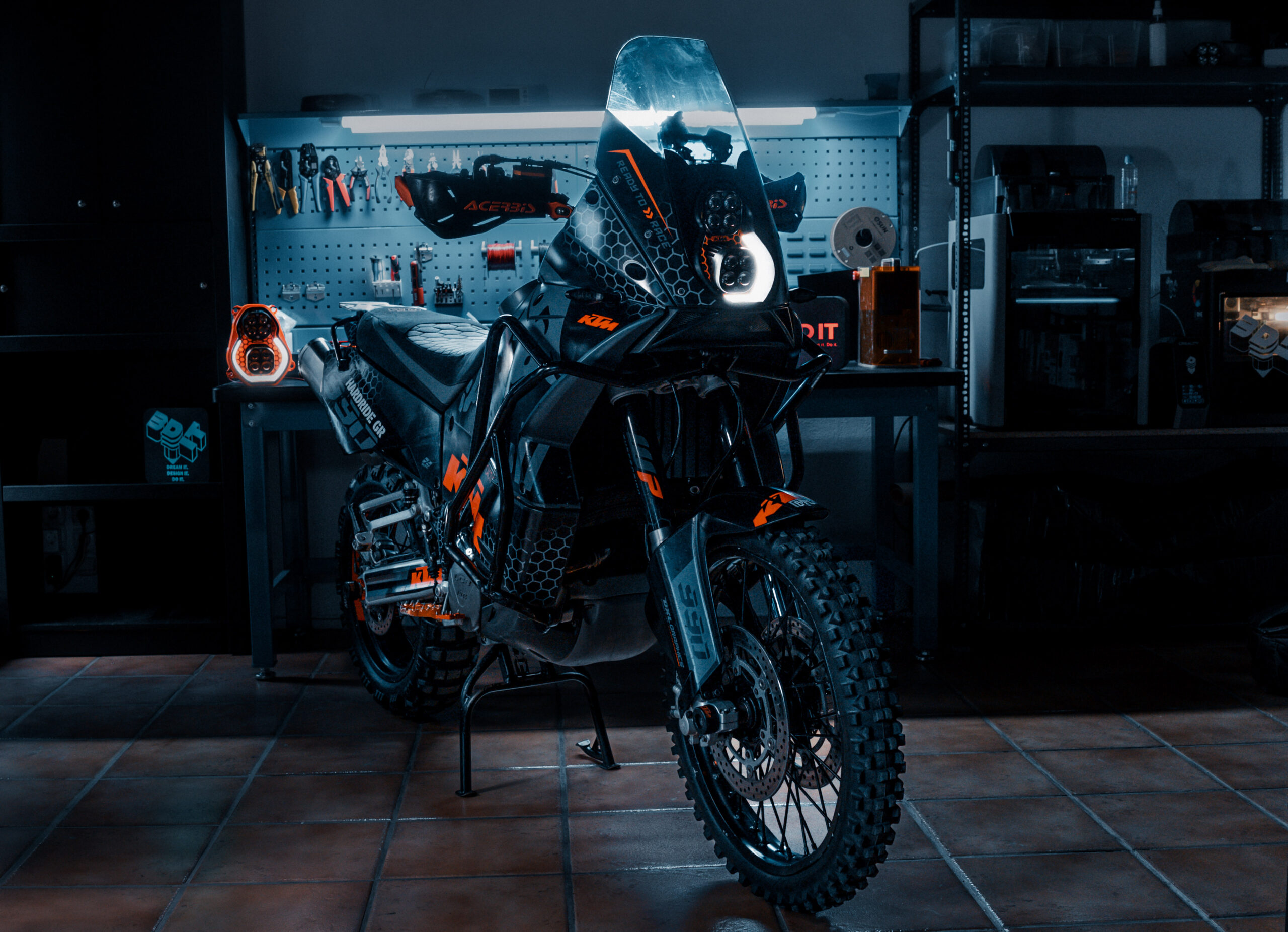 KTM adventure motorcycle with custom LED headlight by 3Dit in workshop garage setting