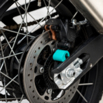 Close-up of the 3Dit CFMOTO 450MT rear ABS cover installed near the rear brake assembly and axle system.